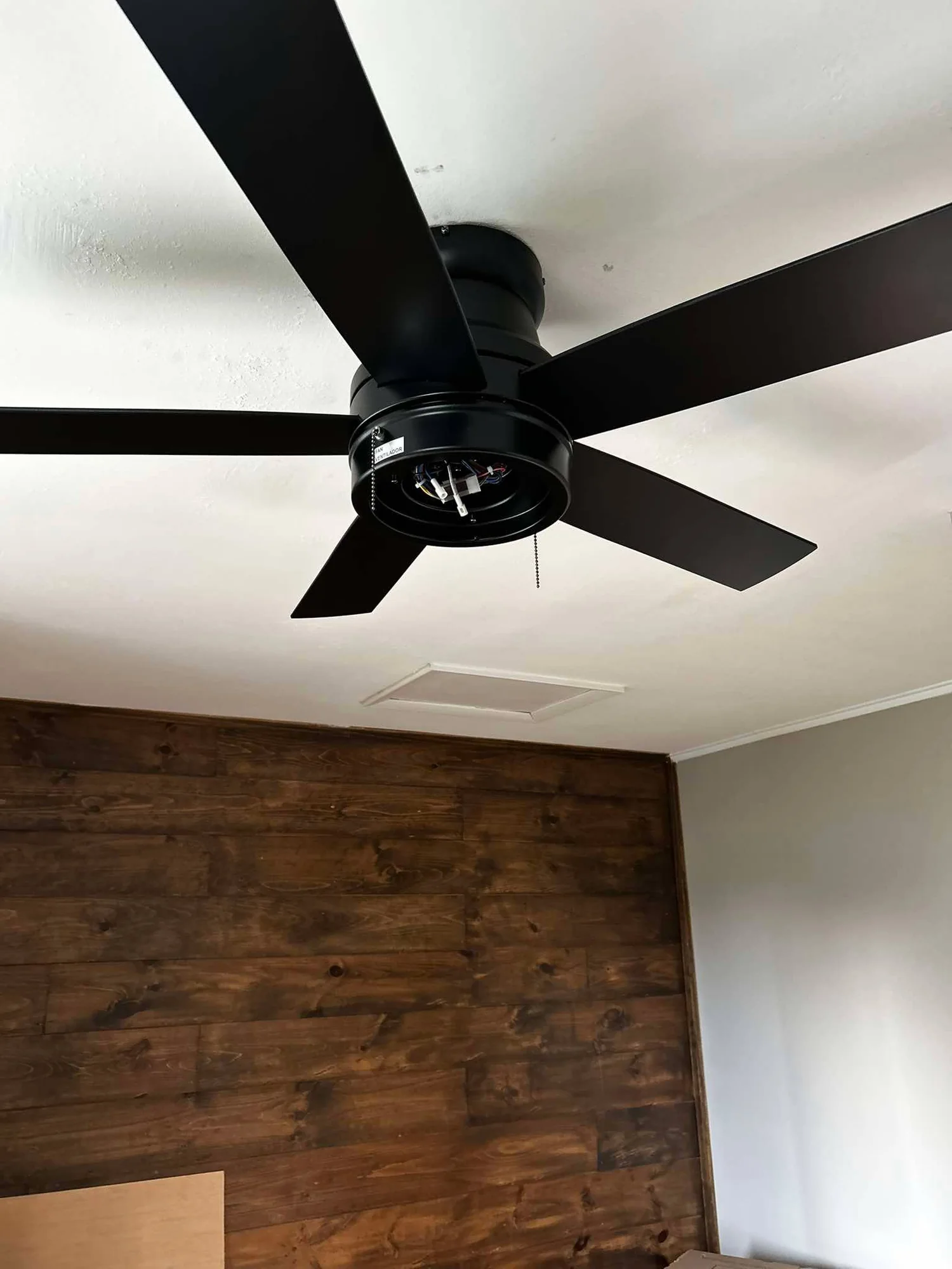 Ceiling fan installed in a finished Tri-Cities room with wood accent wall